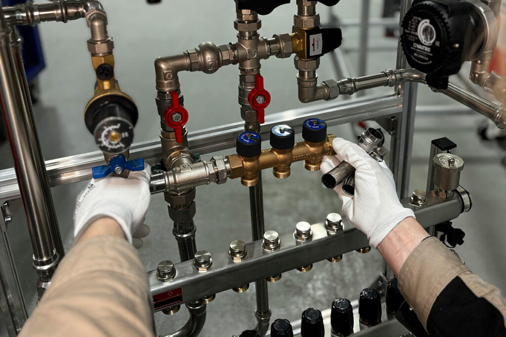 A man working on complex pipe systems, showcasing the technical skills required in how to become a plumber.
