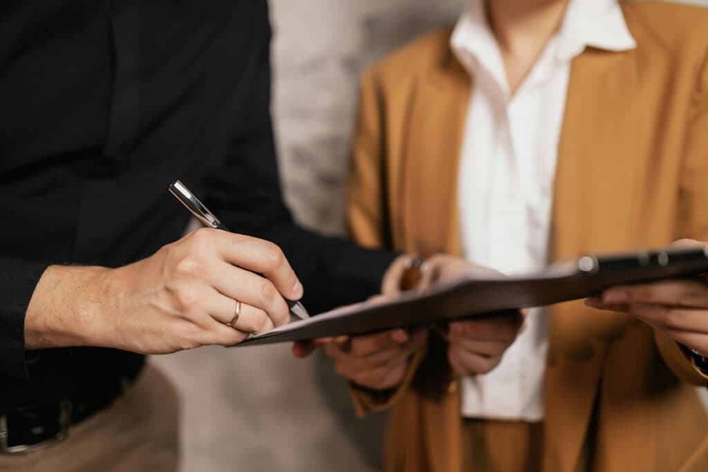 Professionals signing a document, representing the steps of certification and licensing in how to become a plumber.