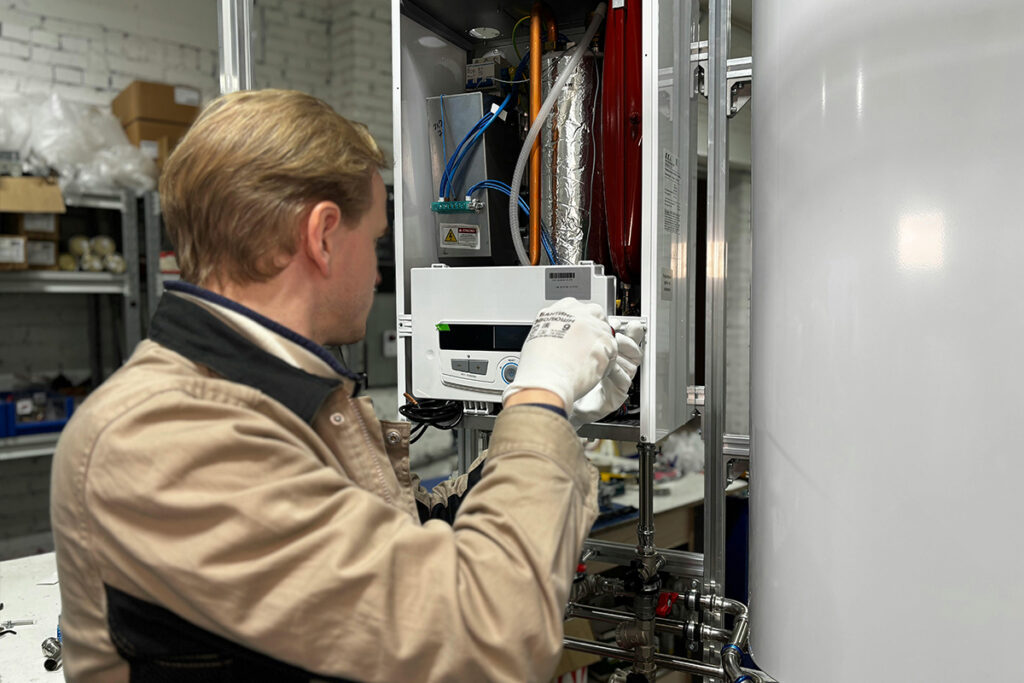 A technician repairs a unit in a workshop, showing hands-on tasks included in his HVAC salary.